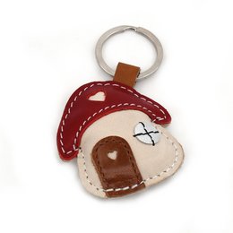 Handmade leather keychain in the shape of a fairy house, featuring a stitched design and a metal ring for attaching to keys.