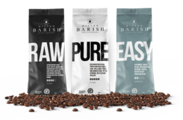 Three bags of Barish coffee beans, including "Raw", "Pure", and "Easy" varieties. The beans appear to be whole, roasted coffee beans.