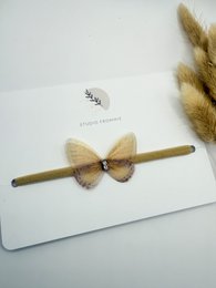 Soft, plush hairband with a bow accent in a neutral color palette, perfect for accessorizing kids' outfits.