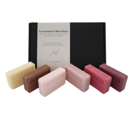 A set of 6 artisanal soap bars in various scents including cassis, unicorn, popcorn, princess, chocolate, and cherry. The soap bars are presented in a gift box.