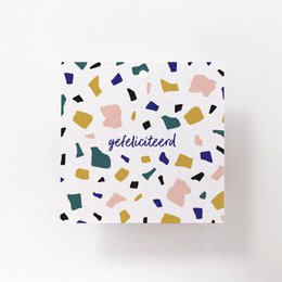 Rectangular gift box wrapped in pink paper with a decorative tag and dried flowers. The gift box appears to be for a congratulatory occasion.