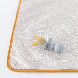 Waterproof splat mat with geometric pattern, orange trim, machine washable feeding mat for babies.