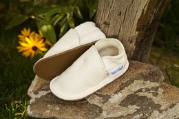  Soft, comfortable white slippers with a simple, minimalist design. Suitable for indoor or outdoor wear.