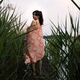 Kilim-patterned orange towel with fringe, made of cotton.