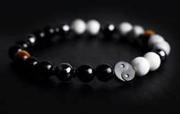 Yin Yang bracelet with black and white beads in various sizes, featuring a Yin Yang symbol charm.