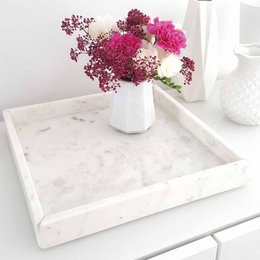 Square white marble tray with decorative pink and white flowers in a vase.