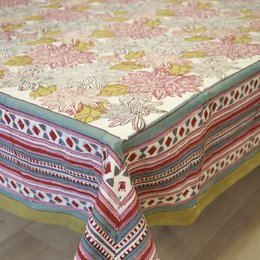  Rectangular cotton tablecloth printed with a vibrant floral and paisley pattern in shades of pink, yellow, and green. The tablecloth has a textured, woven appearance and a decorative border.