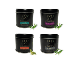 A set of four tea canisters in black with colorful labels featuring different tea flavors - green tea, chamomile, peppermint, and black tea. The canisters have a sleek, modern design and appear to be made of high-quality materials.
