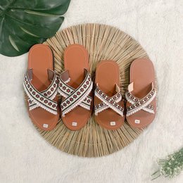 Bohemian-style sandals with a woven straw base and leather straps in a variety of colors, including tan and red. The straps feature intricate embroidered patterns for a stylish, boho-chic look.