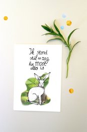 A whimsical illustration featuring a white rabbit and a handwritten message on a card. The image includes green leaves, white flowers, and a simple, minimalist design.