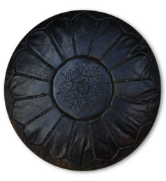 Black leather ottoman with intricate star-shaped pattern, suitable for use as a footrest or extra seating in a living room or bedroom.