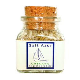  Oregano salt in a glass jar with a cork lid. The salt contains natural oregano flakes and is packaged with a sailboat logo, indicating a seaside or coastal theme.