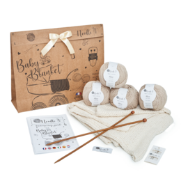 Beginner's knitting kit with needles and supplies for making a baby blanket. Includes ecru-colored yarn, knitting needles, and instructions.