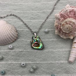 Colorful paua shell pendant necklace with natural, ocean-inspired design. Features a unique, iridescent shell shape and vibrant green and pink hues. Ideal for ocean lovers, surfers, and those who appreciate natural, handcrafted jewelry.