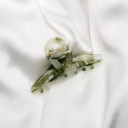 Green hair clip with a twist design, made of plastic material.