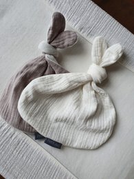 Soft, plush cuddle cloth in a neutral taupe color with a button rabbit design, perfect for comforting and soothing.