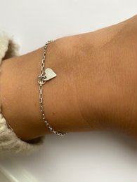  Delicate silver pendant bracelet with a heart-shaped charm.