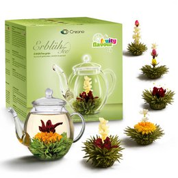 Blooming tea set with glass teapot and assorted flowering tea balls in green and red colors.
