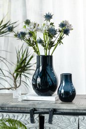 Deep blue glass vase with elegant, modern design. Tall, rounded shape in high-quality glass material.