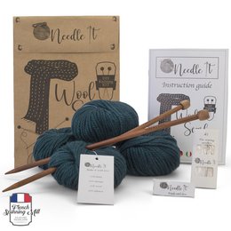 Dark green knitting kit with needles and wool for making a scarf. Includes all the necessary materials for a beginner to learn knitting.