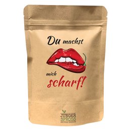 A spicy, round chili pepper product with a bold, fiery flavor. The product is packaged in a tan pouch with a graphic of red lips and the text "Du machst mich scharf!" which translates to "You make me hot!"