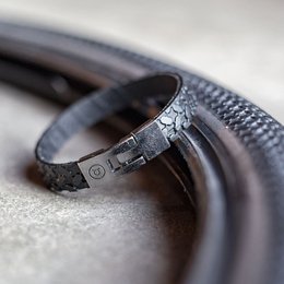  Upcycled bicycle tire bracelets in various colors including brown, white, black, reflex, gloom, and corcy. Made from recycled materials with a unique, textured design.