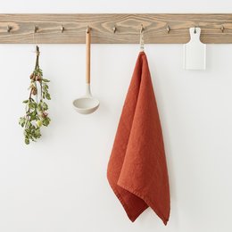 Baked clay linen kitchen towel in a warm terracotta color, featuring an absorbent and durable linen material for everyday kitchen use.