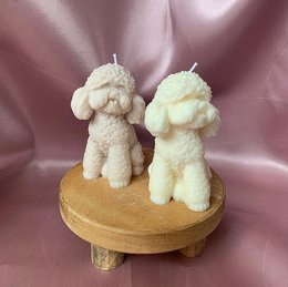 Soft, fluffy poodle-shaped wax candles in natural, gray, and light brown colors. Ideal for home decor or gift-giving.