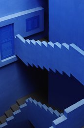 Geometric abstract painting with blue tones and sharp angles, creating a sense of depth and movement.