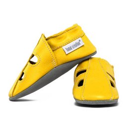 Leather summer slippers in a vibrant yellow color, featuring a simple, minimalist design with a strap across the foot. The slippers have a comfortable, flexible sole suitable for indoor or outdoor wear.
