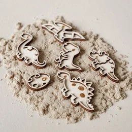 Small filling trays with dinosaur-themed shapes in various colors and materials. Includes shapes like dinosaurs, footprints, and other dinosaur-inspired designs.