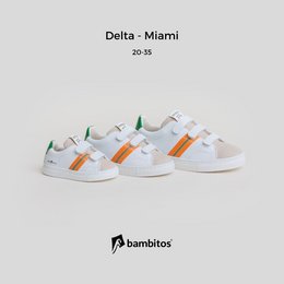 White casual sneakers with velcro straps, featuring orange and green accents. Suitable for kids' sports activities.