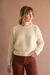 Beige organic cotton sweater with a relaxed, oversized fit. Features a round neckline and long sleeves.