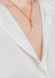 Elegant necklace with a gold-tone pendant on an orange cord. The pendant features a minimalist teardrop design, perfect for adding a touch of sophistication to any outfit.