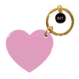  A pink heart-shaped keychain with a gold metal ring and a black circular charm that says "BFF".