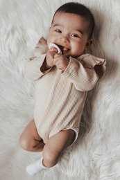 Beige ruffle romper for babies, available in sizes 0-3m, 3-6m, 6-12m, 12-18m. Made of soft, comfortable material with ruffled details.