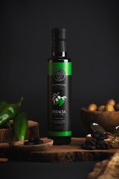 Olive oil flavored with fresh green chili, featuring a bottle of olive oil, cheese, grapes, and other accompaniments. The description highlights the key product details, including the flavor profile, to enable effective semantic search.