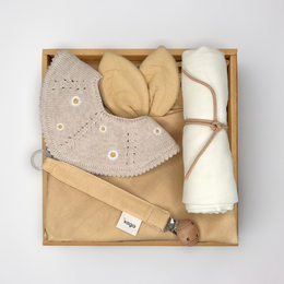  A gift box containing various soft, textured items in shades of yellow and brown, including a teething ring, a rattle, and other baby toys. The box is decorated with a bumblebee motif.