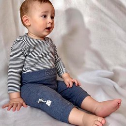This organic baby kimono bodysuit features a striped pattern in navy and white colors. The long-sleeved design provides warmth and comfort for infants. The wrap-around style allows for easy dressing and undressing.