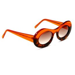 Translucent orange sunglasses with animal print frames, oval shaped lenses, and a bold, stylish design.