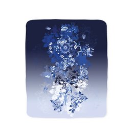 Plaid Delft Blue 'Settle Down' throw blanket with a floral pattern in shades of blue and white, featuring a soft, cozy texture and a modern, stylish design.