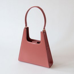 A pink, structured handbag with a rectangular shape and a single top handle.