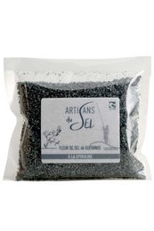 Guérande salt flower with spirulina, a seasoning product. The salt has a distinctive black color and a unique floral shape, providing a visually appealing and flavorful addition to dishes.