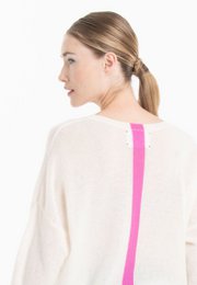  A loose-fitting, v-neck sweater in a soft, off-white color. The sweater has a relaxed, casual style that would pair well with denim shorts or jeans.