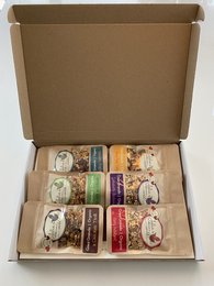 A variety pack of granola bars in a cardboard box. The granola bars come in different flavors and are arranged neatly in the box.