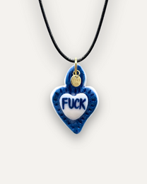 Blue heart-shaped porcelain pendant with "FUCK" text in white. Pendant has a gold-tone metal loop for hanging.