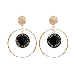 Gold-coated coin hoop earrings with a black circular accent. The earrings have a modern, stylish design that would complement a variety of outfits.