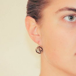 Capricorn earrings in silver and gold-plated silver, featuring a circular design with the Capricorn zodiac symbol.