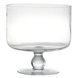 A clear glass trifle bowl filled with various citrus fruits, including lemons, limes, and oranges.