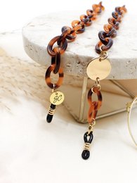  Tortoiseshell-colored beaded necklace with gold-tone pendant and black accents. Stylish and versatile accessory.